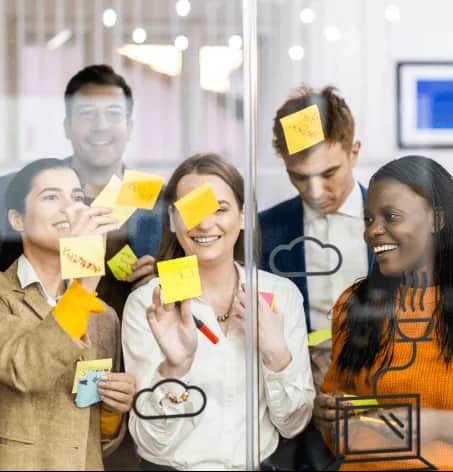 Photo of people in front of whiteboard with sticky notes